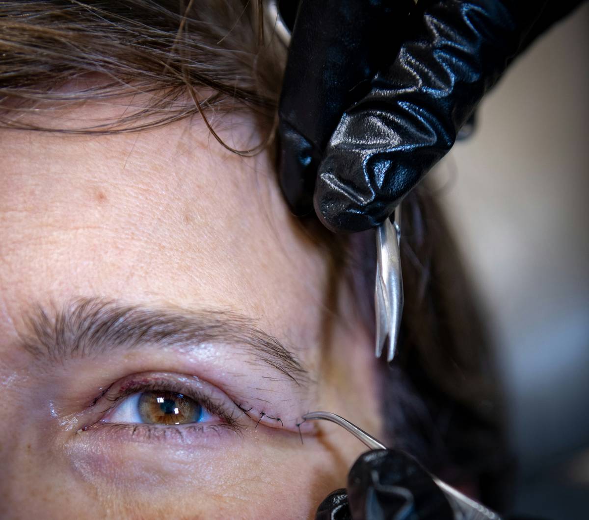 woman applying long-lasting eyebrow tint with brush on clean brows